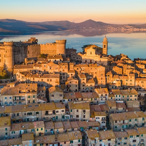 An aerial view of Bracciano at sunset with a lake in the background