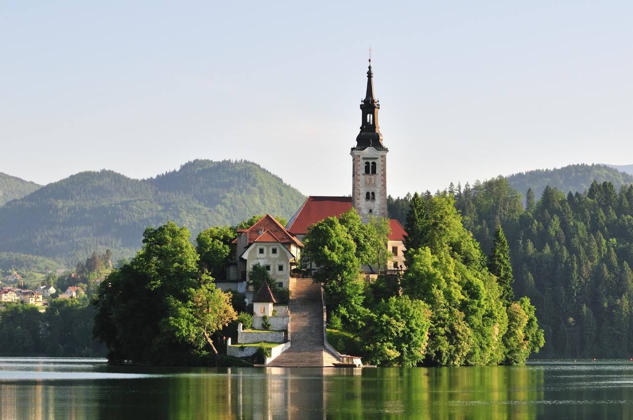 Bled Island, in the middle of Lake Bled, covered in green trees