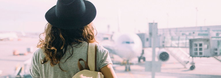 girl-at-airport-looking-at-airplane